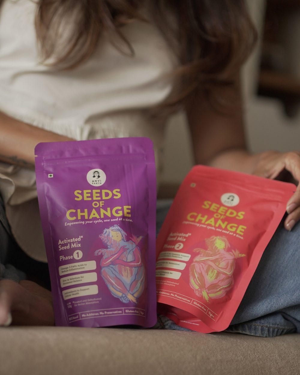 Woman seated on a sofa with both Seeds of Change pouches in her lap