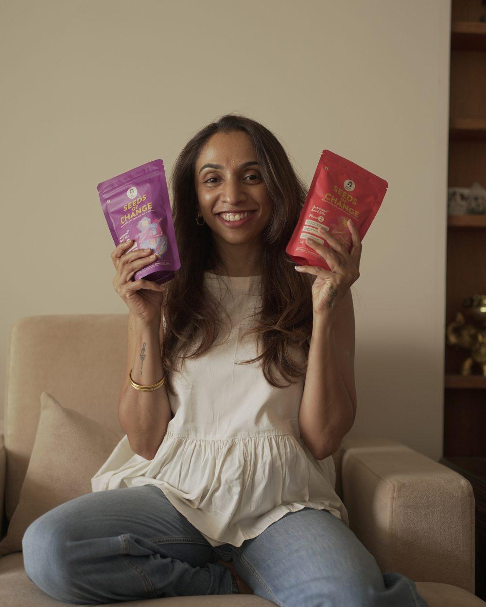 Smiling woman holding up the Phase 1 and Phase 2 pouches
