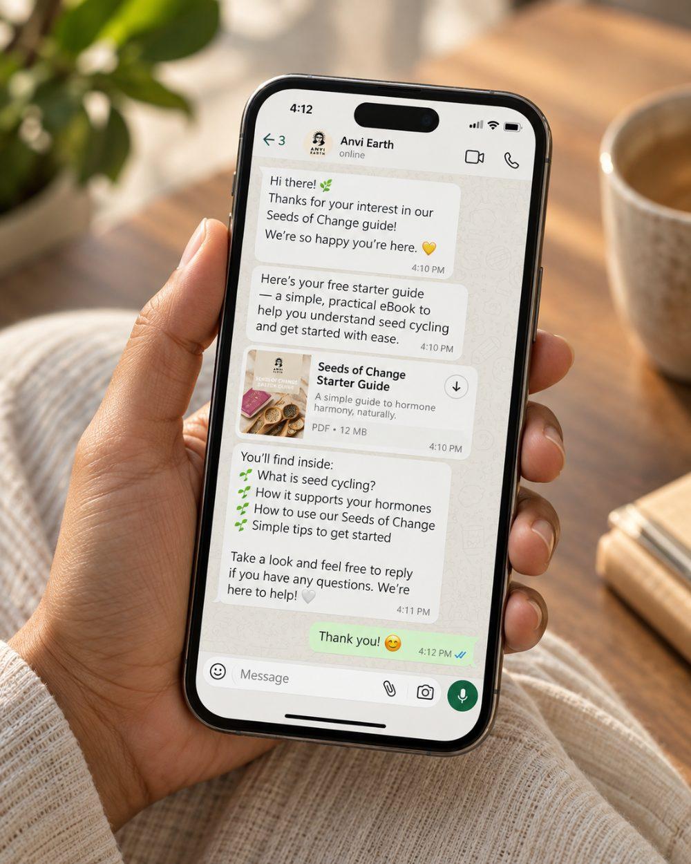 A hand holding a phone showing the Seeds of Change starter guide arriving on WhatsApp