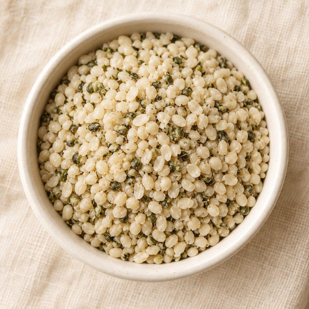 Macro photograph of raw hemp seeds in a small ceramic bowl
