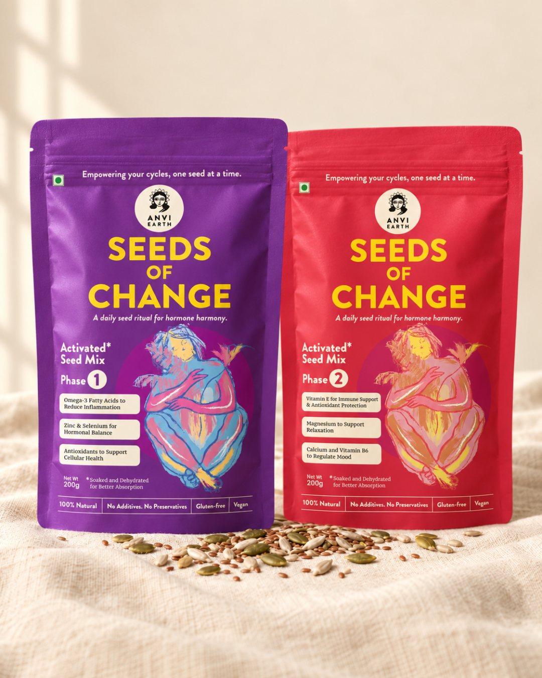Seeds of Change Phase 1 and Phase 2 pouches standing together on cream linen, seeds scattered at their base