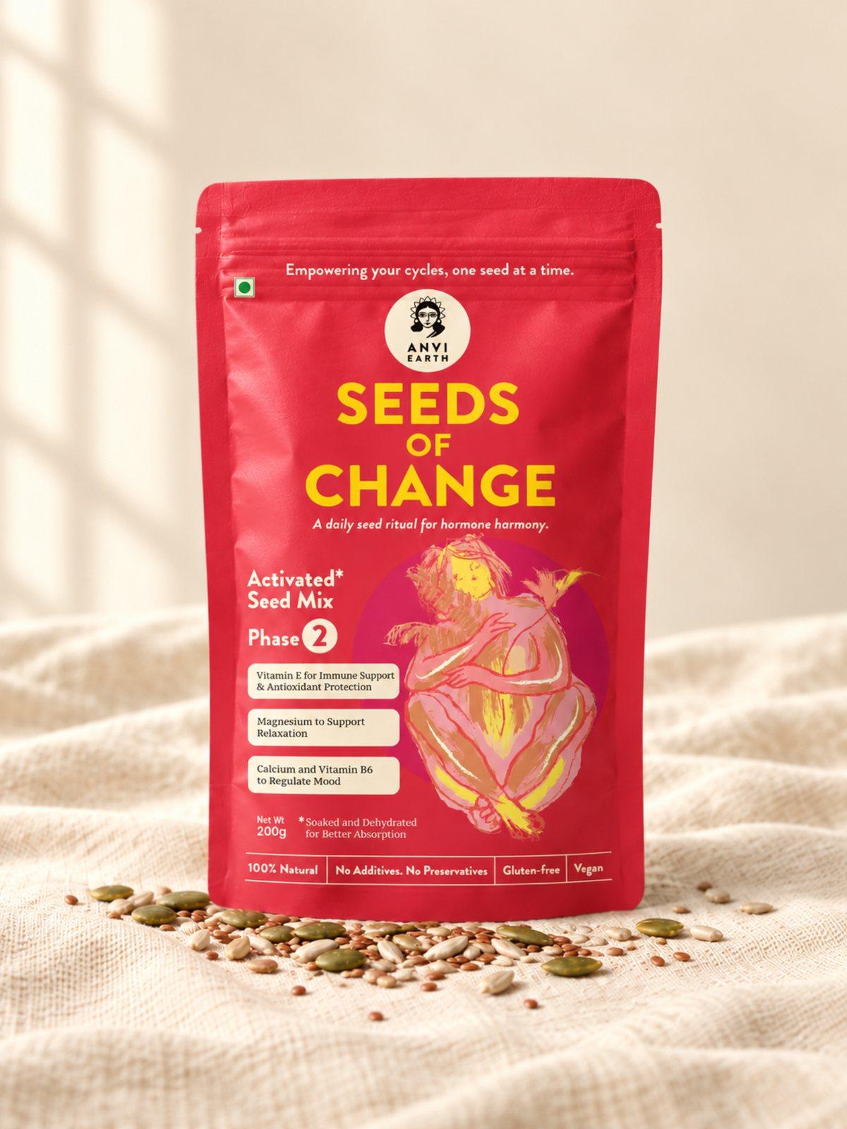 Seeds of Change Phase 2 pouch standing on cream linen with its seeds scattered at the base